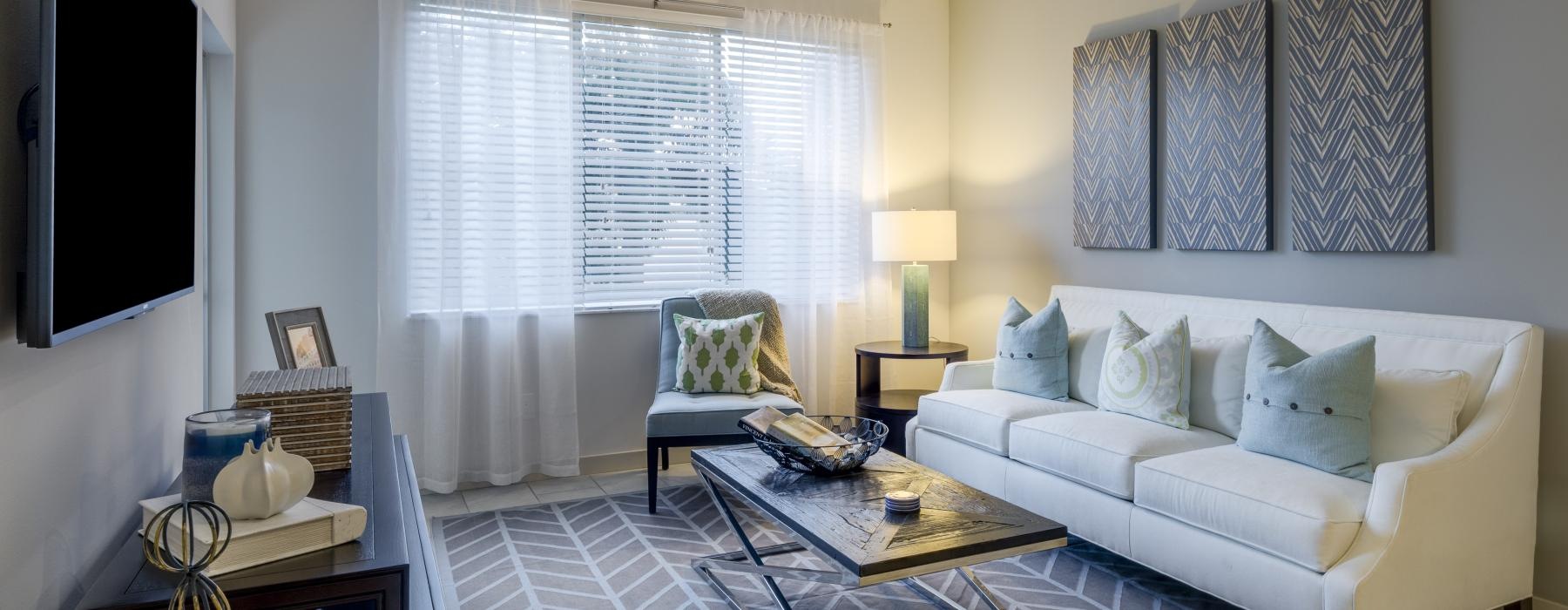 a living room with a white couch and a fan