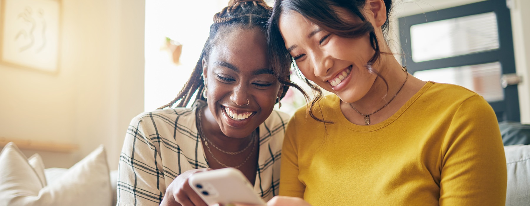 two women smiling looking at a device