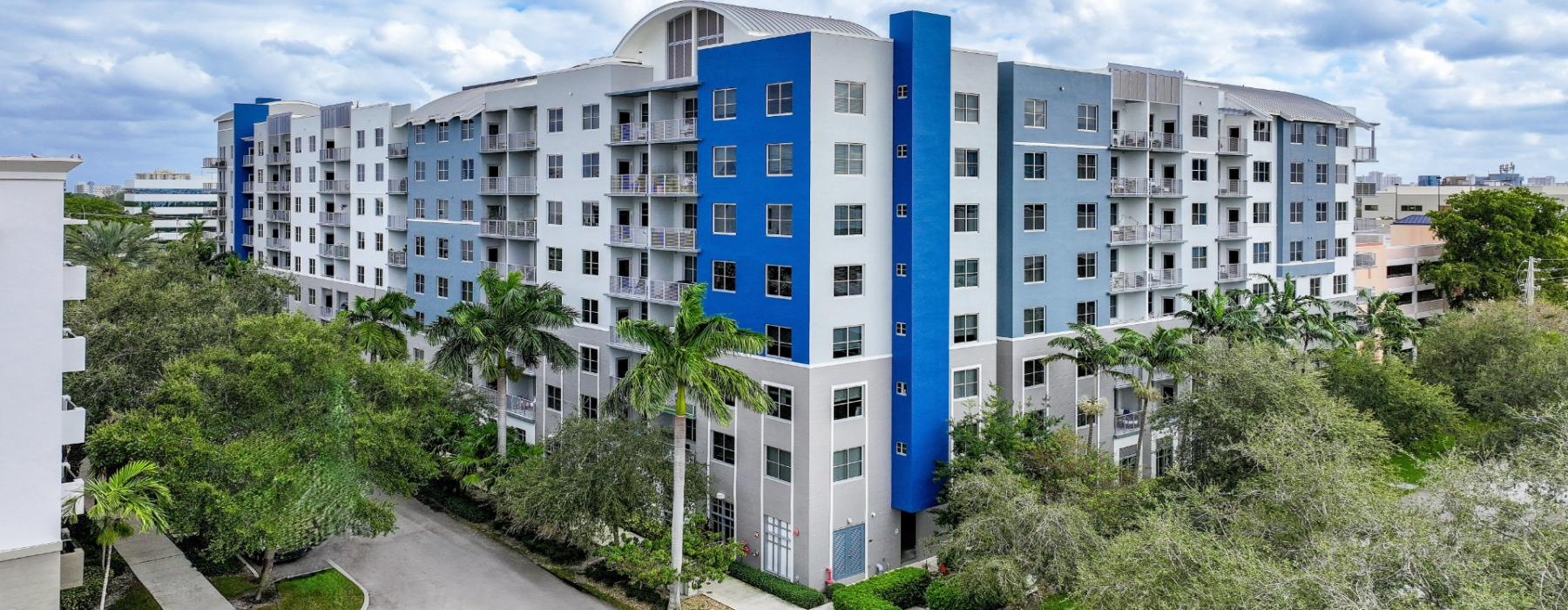 a building with trees and bushes in front of it