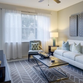 a living room with a white couch and a fan